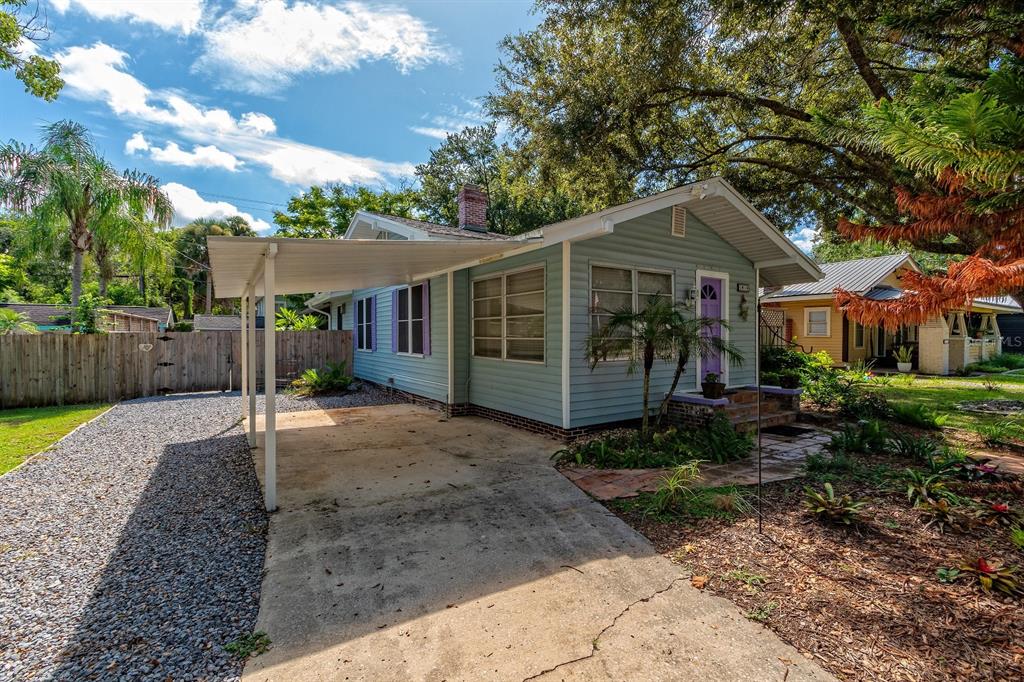 A light blue house with a carport, purple shutters, and a front yard with trees — 1919 S PALMETTO AVENUE, SANFORD, FL