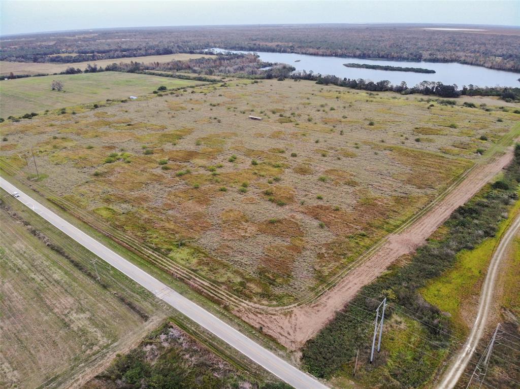 An aerial view shows a large, grassy, undeveloped lot bordered by a road and trees — OLD BOWLING GREEN ROAD, FORT MEADE, FL