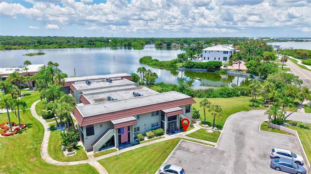 The exterior of a two-story apartment building features a ground-floor unit with screened patios — 1001 S BAYSHORE BOULEVARD UNIT 101, SAFETY HARBOR, FL