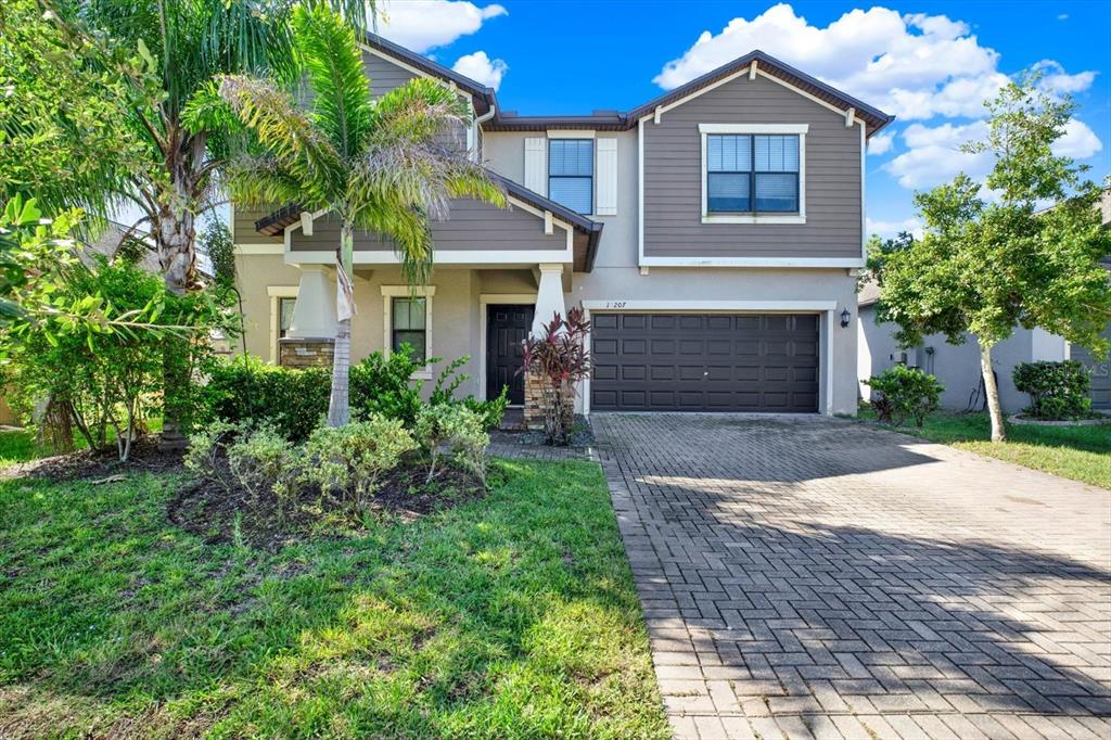 A two-story house with a brown garage, gray siding, and a paved driveway — 10207 COUNT FLEET DRIVE, RUSKIN, FL