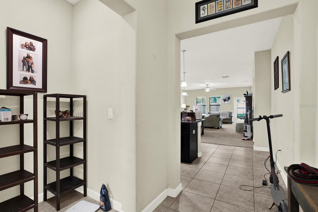 A tiled entryway leads into a living area with carpeted floors and a ceiling fan — 10207 COUNT FLEET DRIVE, RUSKIN, FL