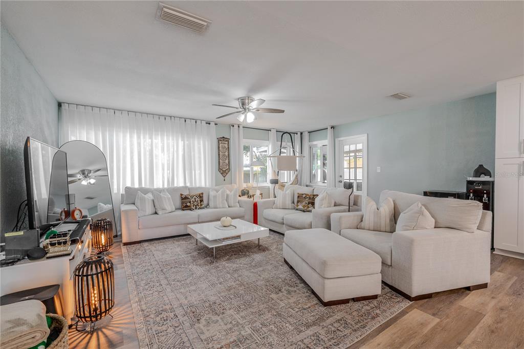 A living room features white sofas, a central coffee table, and a large area rug — 11615 PARK BOULEVARD, SEMINOLE, FL
