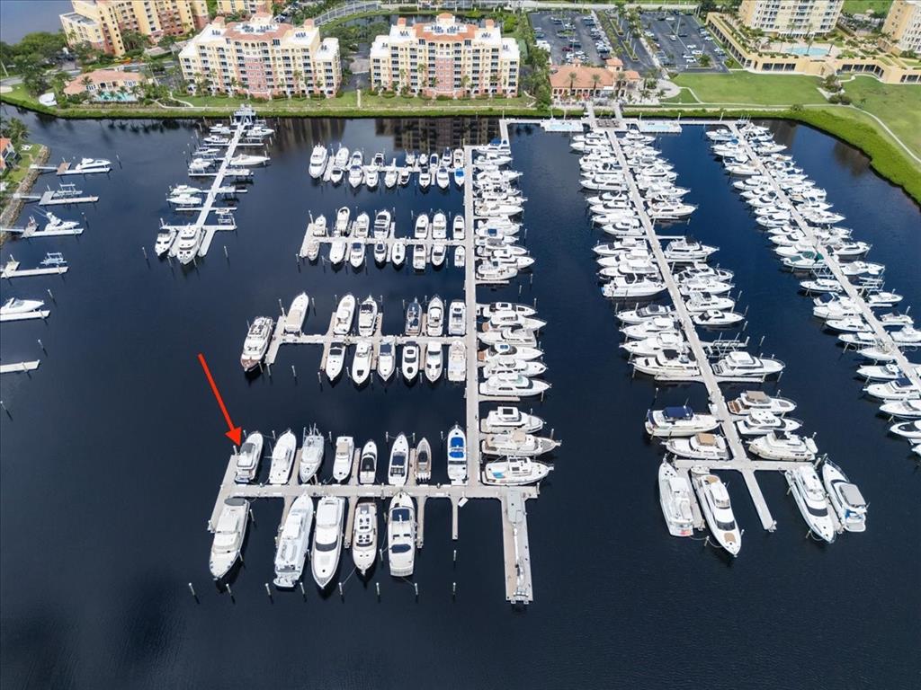 An aerial view shows a marina with numerous boats docked in slips along wooden piers — 102 RIVIERA DUNES WAY UNIT S-36, PALMETTO, FL