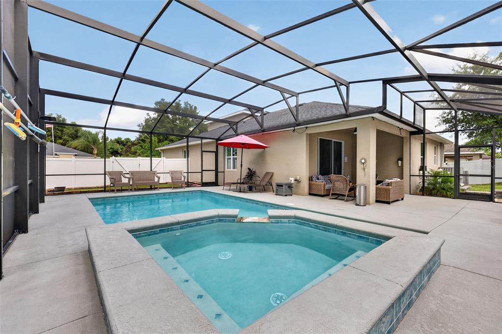 A screened-in patio features a swimming pool, a raised spa, and outdoor furniture — 1450 OSPREY RIDGE DRIVE, EUSTIS, FL