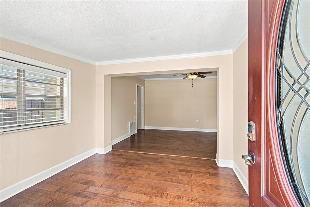 An interior view shows a living area with hardwood floors and an adjacent dining space — 805 W BRADDOCK STREET, TAMPA, FL