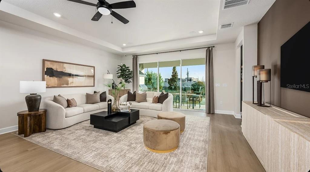 A kitchen features wood cabinets, a large white island with seating, and stainless steel appliances — 7825 CENTAURUS WAY, SARASOTA, FL