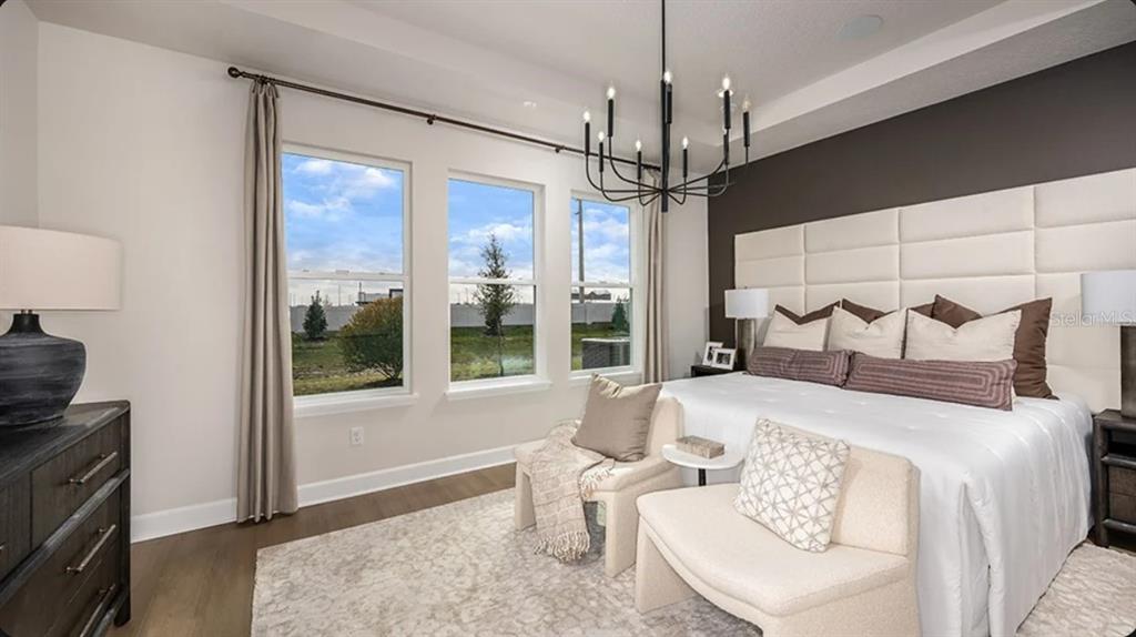 A modern living room features a white sofa, a black coffee table, and sliding glass doors — 7825 CENTAURUS WAY, SARASOTA, FL