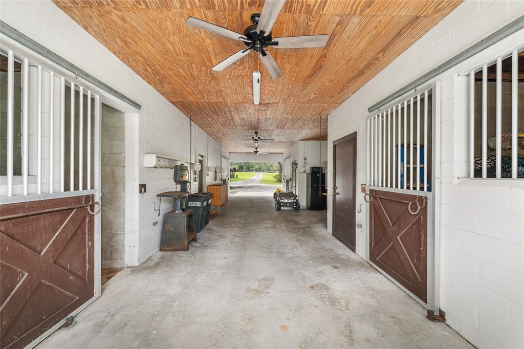 A single-story house with a covered front porch, gray siding, and a large grassy yard — 10871 SE COUNTY ROAD 326, MORRISTON, FL