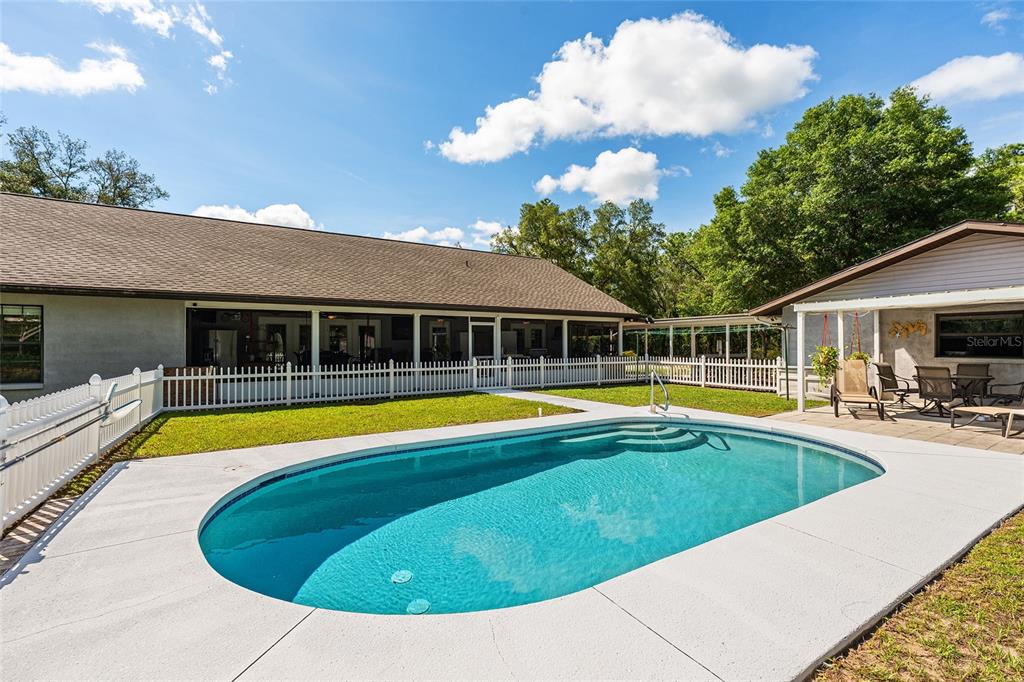 An aerial view shows a rural property with scattered trees, open land, and nearby roads — 10871 SE COUNTY ROAD 326, MORRISTON, FL