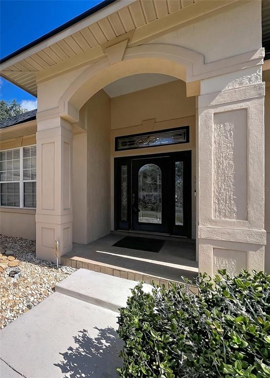 The exterior of a house features a covered entryway with a decorative front door — 1826 WESTMINSTER COURT, LAKELAND, FL
