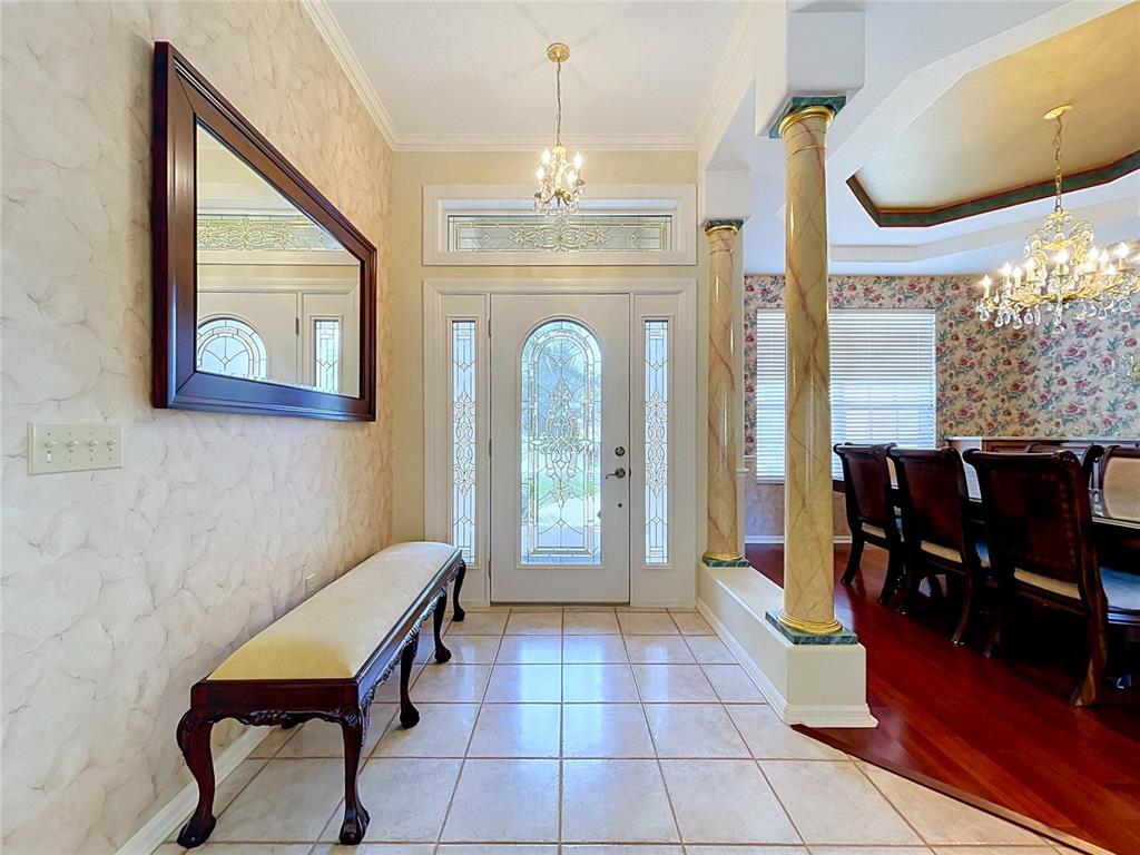 An entryway features a tiled floor, a bench, a mirror, and decorative columns near a dining room — 1826 WESTMINSTER COURT, LAKELAND, FL