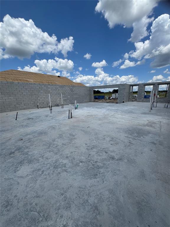 An unfinished construction site features a concrete slab foundation and gray concrete block walls — 30237 RUSTIC MILL STREET, MOUNT DORA, FL