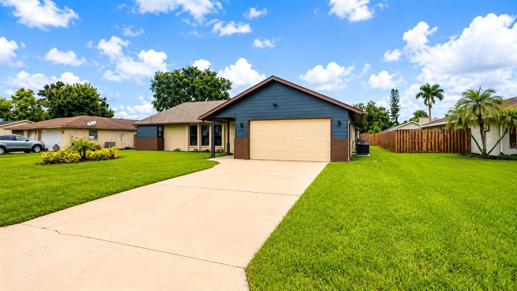 A single-story house with a tan exterior, brown brick accents, and a two-car garage — 1526 GEORGETOWNE LANE, SARASOTA, FL