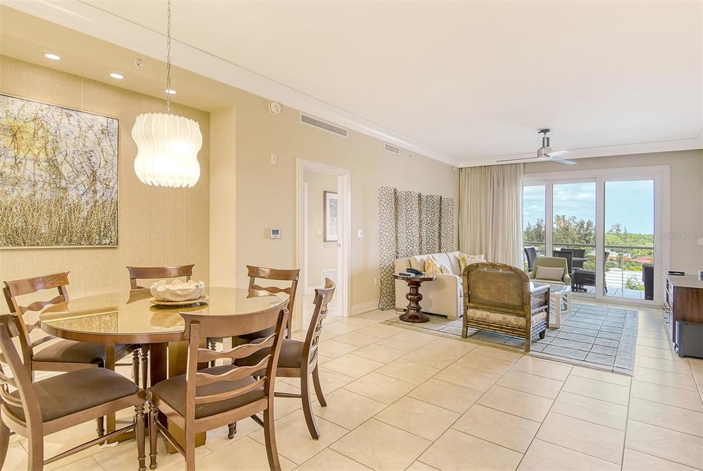 A dining area and living room with tile floors, neutral walls, and a balcony view — 915 SEASIDE DRIVE UNIT 402, Weeks 10-13, SARASOTA, FL