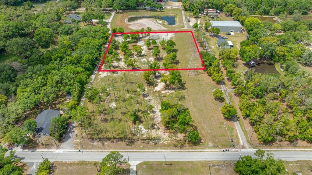 An aerial view shows a rectangular plot of land outlined in red near a road — 00 HANNA ROAD, LUTZ, FL