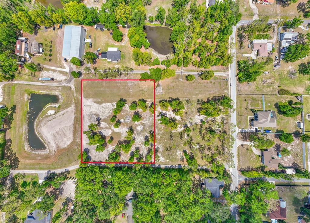 An aerial view shows a rectangular vacant lot outlined in red within a rural neighborhood — 00 HANNA ROAD, LUTZ, FL