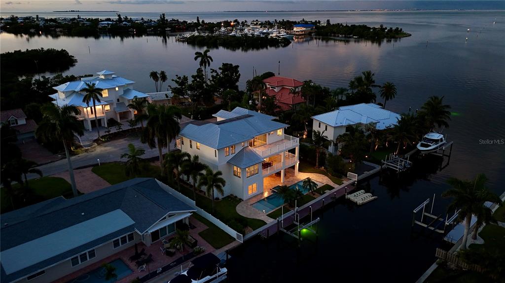 An aerial view of a three-story white house with a metal roof and palm trees — 529 77TH STREET, HOLMES BEACH, FL