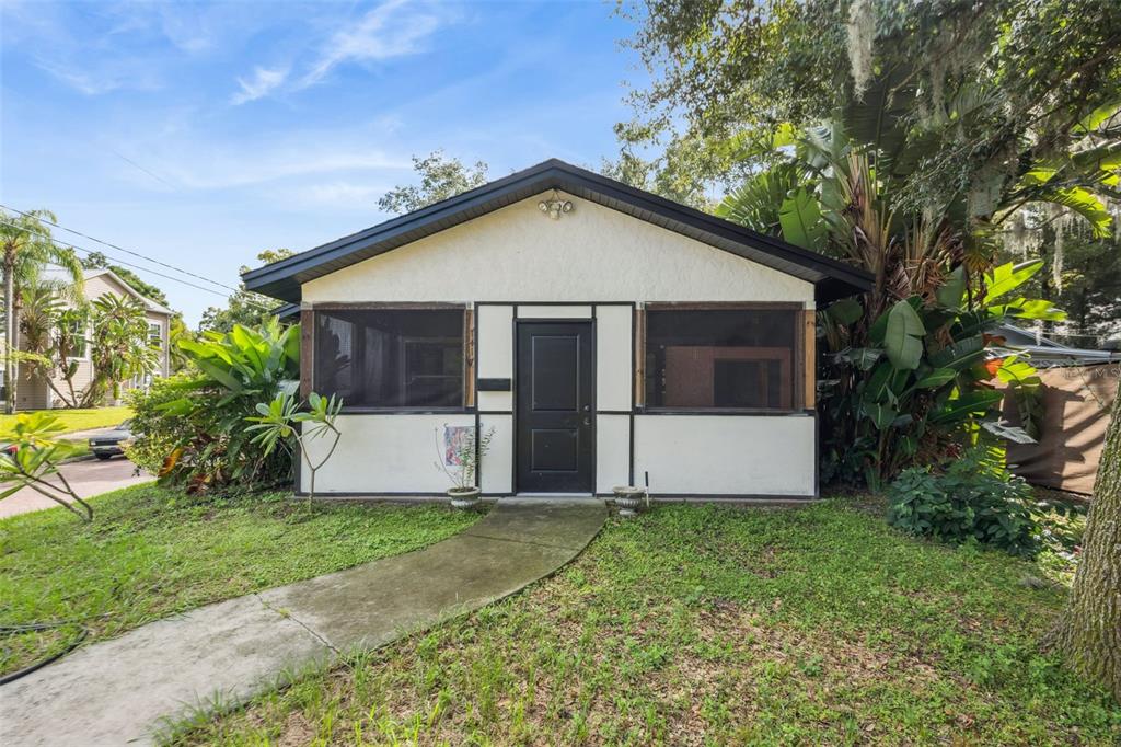 A small, single-story house with a screened-in front porch and a concrete walkway — 1417 BELGRADE AVENUE, ORLANDO, FL
