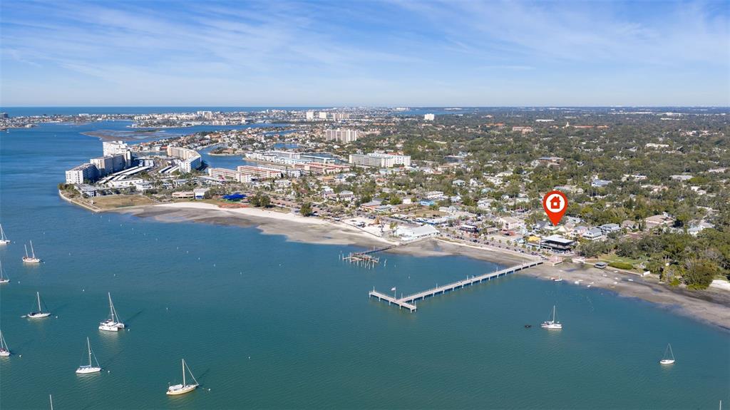 An aerial view shows a coastal town with a long pier extending into the water — 5429 ESSEX AVENUE S, GULFPORT, FL