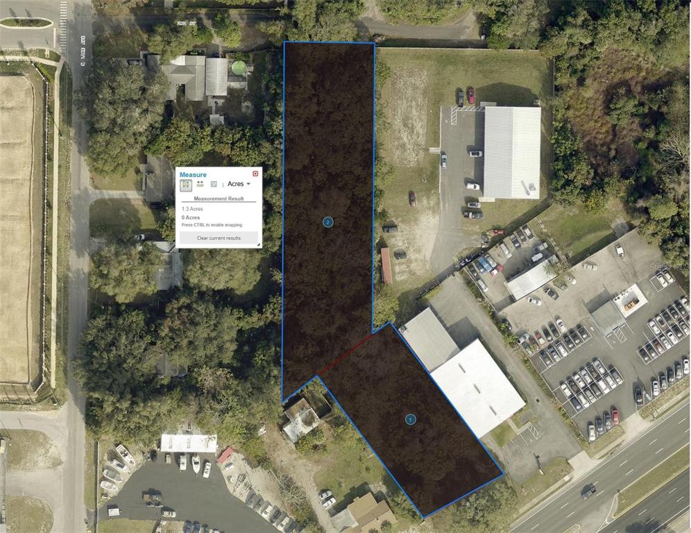 An aerial map shows two adjacent, highlighted parcels of land surrounded by commercial and residential properties — 1602 E MAIN STREET, LEESBURG, FL