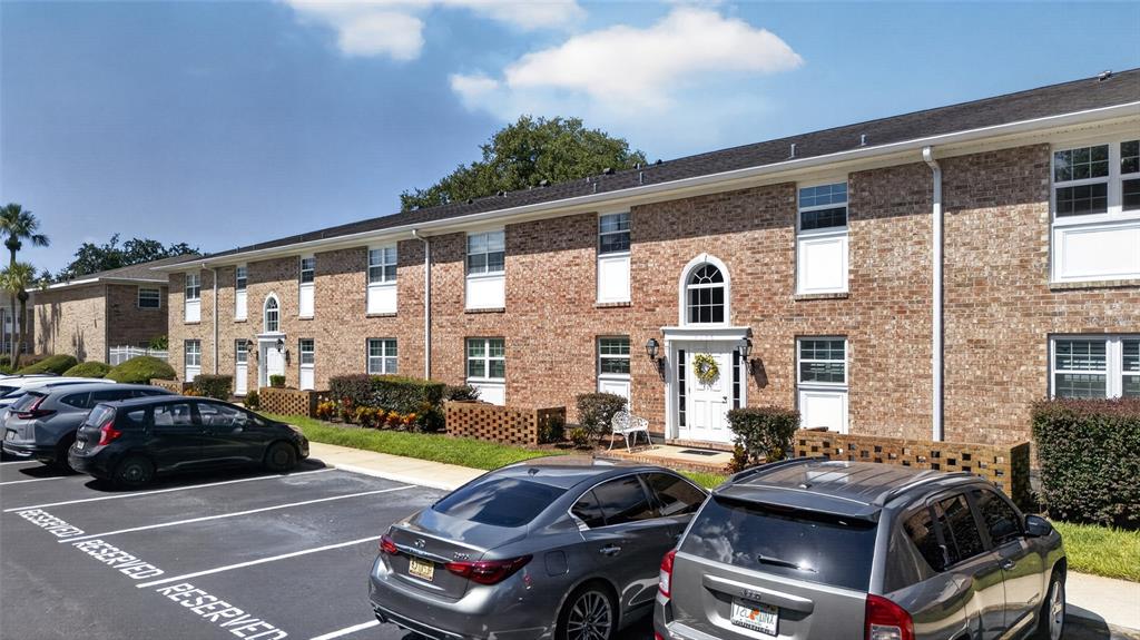 A two-story brick apartment building features white-framed windows and a parking lot in front — 4386 LAKE UNDERHILL ROAD UNIT D, ORLANDO, FL