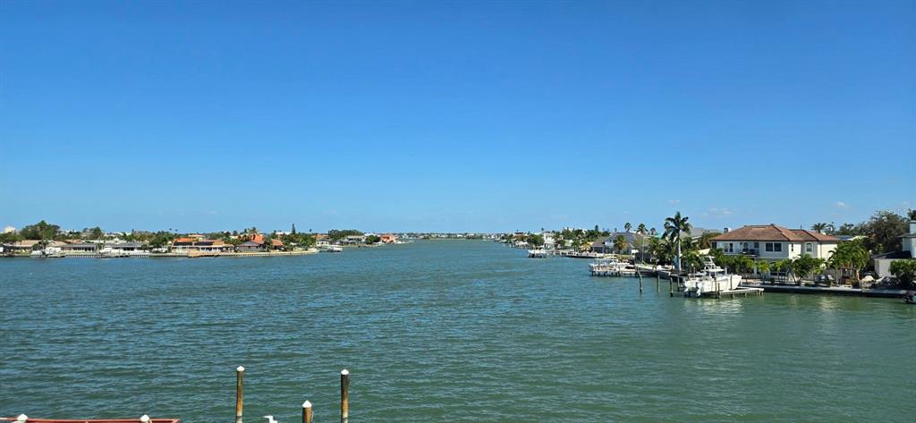 A wide-angle view of a waterway lined with residential homes and private boat docks — 6061 2ND STREET E UNIT 55, ST PETE BEACH, FL