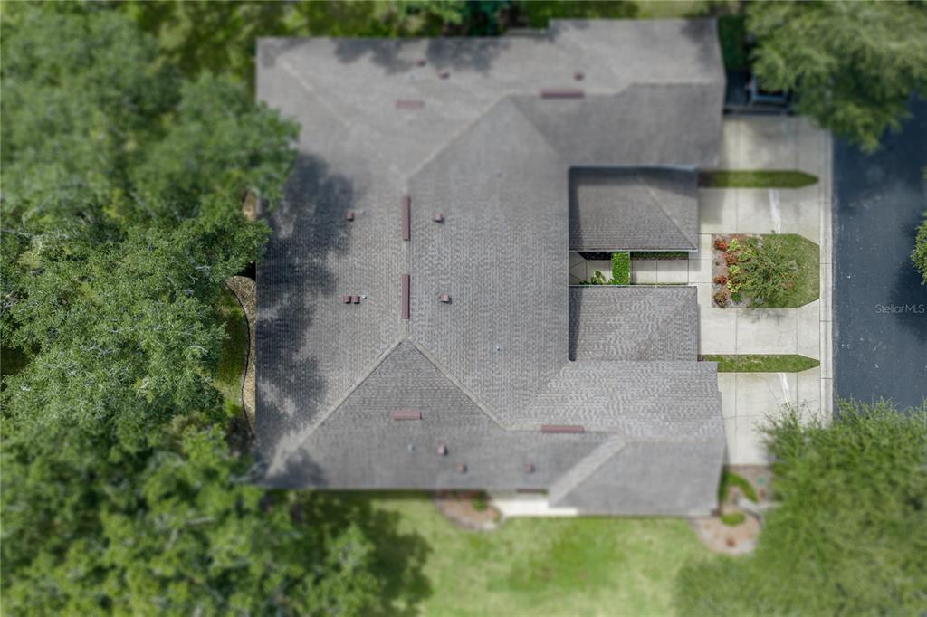 An aerial view shows the shingled roof of a house surrounded by trees and landscaping — 2405 EARLSWOOD COURT, BRANDON, FL