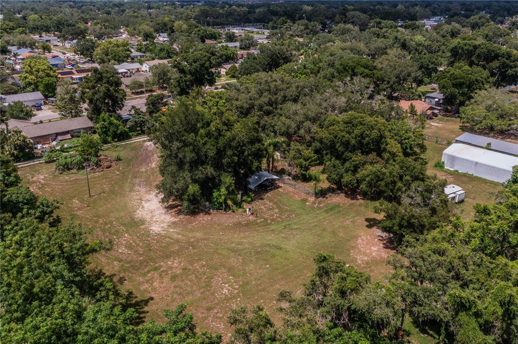 An aerial view shows a large, grassy lot with mature trees and a small carport — 441 OVERHILL DRIVE, BRANDON, FL