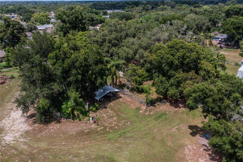 An aerial view shows a house with a carport surrounded by large trees and grass — 441 OVERHILL DRIVE, BRANDON, FL