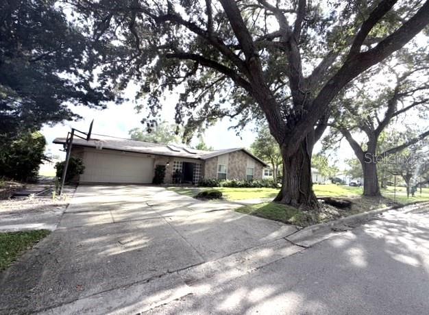 A single-story house with a stone facade and a large tree in the front yard — 2410 SHERBROOKE ROAD, WINTER PARK, FL