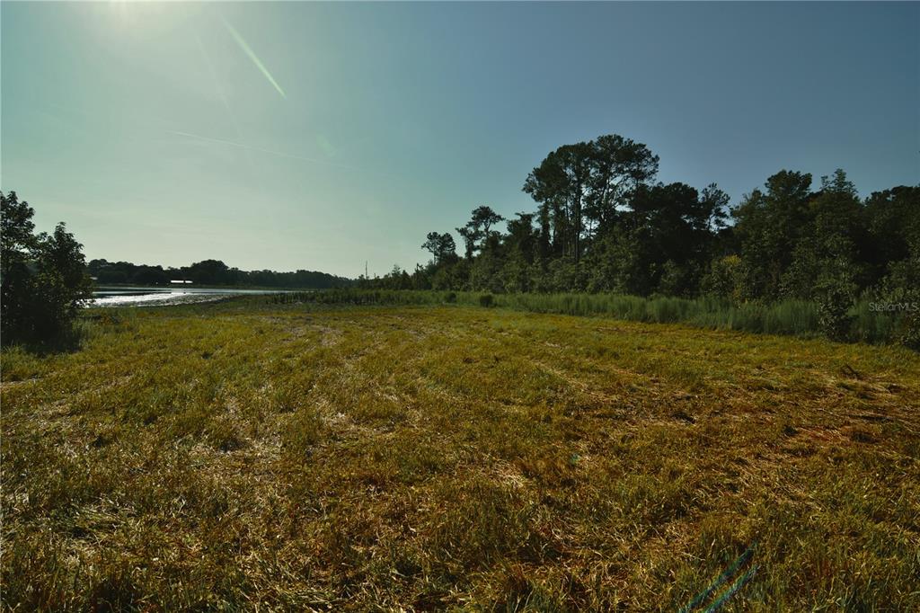 A wide, grassy field leads toward a line of trees and a distant body of water — 00 HALL LAKE ROAD, KEYSTONE HEIGHTS, FL