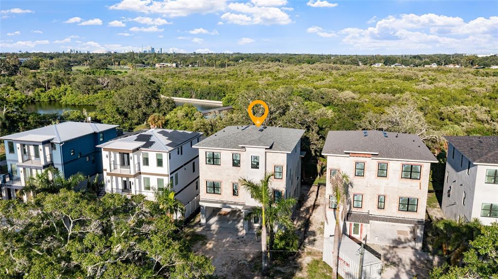 An aerial view shows several modern multi-story houses situated near a wooded area and water — 2614 QUINCY STREET S, GULFPORT, FL