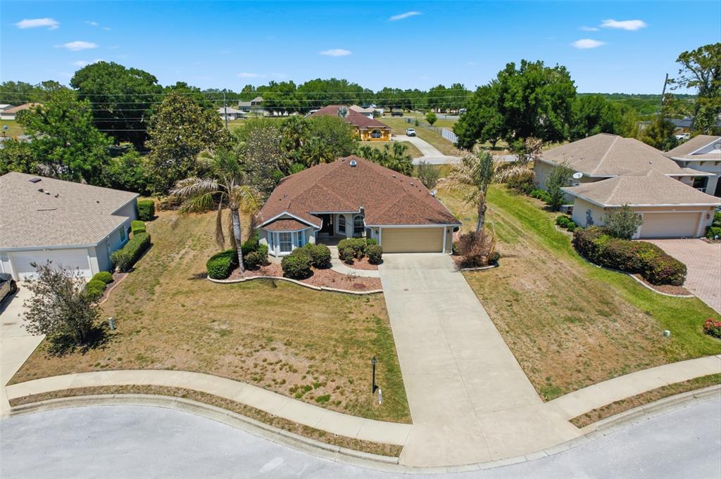 An aerial view shows a single-story house with a brown roof and a concrete driveway — 5013 HARBOR HEIGHTS, LADY LAKE, FL