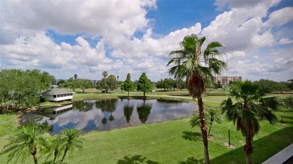 A view of a pond and golf course seen through a window screen — 4570 PINEBROOK CIRCLE UNIT 302, BRADENTON, FL