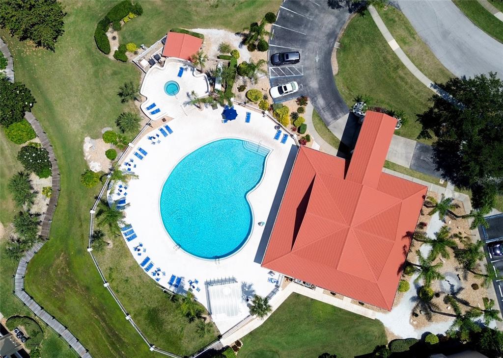 An aerial view shows a swimming pool, a clubhouse, and two tennis courts — 441 BOUCHELLE DRIVE UNIT 202, NEW SMYRNA BEACH, FL