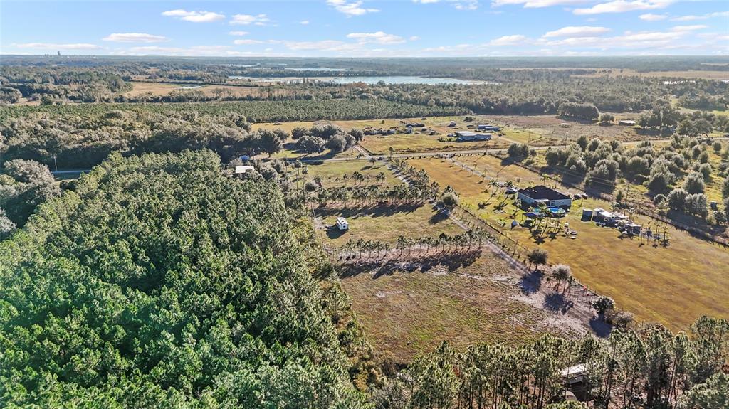 An aerial view shows a large rural property with a dense forest and open fields — 18121 BETHLEHEM ROAD, LITHIA, FL