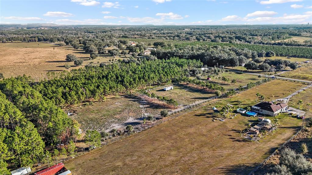 An aerial view shows a large rural property with a house, pool, and wooded areas — 18121 BETHLEHEM ROAD, LITHIA, FL