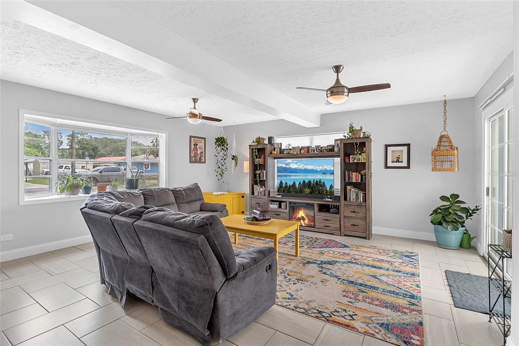 A living room features a grey sectional sofa, a yellow coffee table, and a media console — 855 PEARL DRIVE, MOUNT DORA, FL