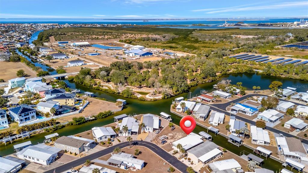 This aerial view shows a waterfront residential neighborhood with a red location pin — 132 W SAINT LUCIA LOOP, APOLLO BEACH, FL