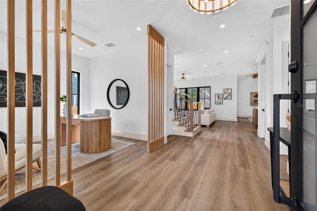 A bright home office with wood slat partitions opens to a hallway with wood flooring — 142 22ND AVENUE N, ST PETERSBURG, FL