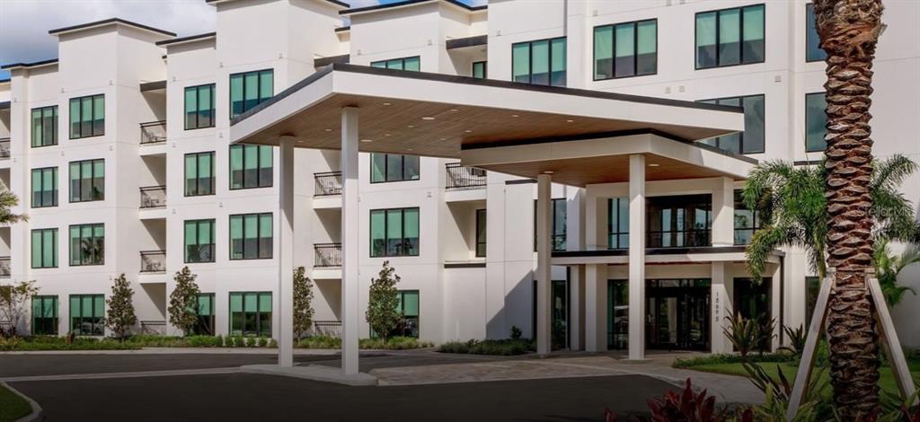 A modern multi-story apartment building exterior featuring a large covered entrance with wood-paneled ceilings — 14501 GROVE RESORT AVENUE UNIT 2129, WINTER GARDEN, FL