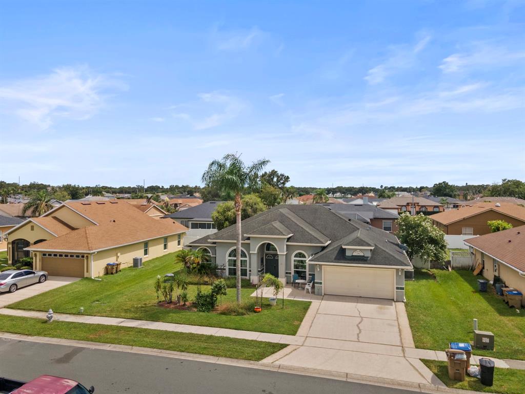 An exterior view of a single-story suburban house with a palm tree and concrete driveway — 2856 MIDDLETON CIRCLE, KISSIMMEE, FL