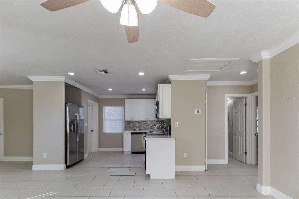 A dining area with a table and chairs sits in front of an open kitchen — 4933 BALBOA DRIVE, ORLANDO, FL