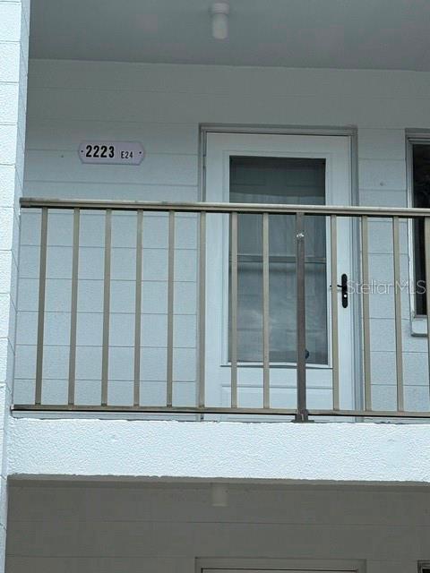 A white exterior balcony features a metal railing and a door with a screen — 2223 SUNSET DRIVE UNIT E24, BRADENTON, FL