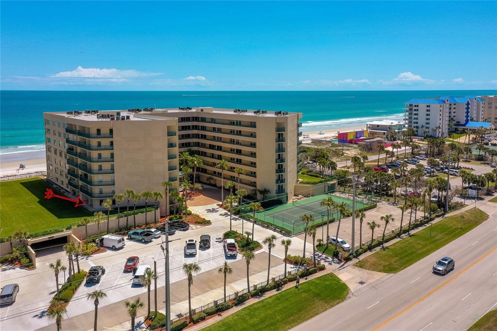 An aerial view shows two beachfront condominium buildings separated by a grassy courtyard and pool — 4575 S ATLANTIC AVENUE UNIT 6101, PORT ORANGE, FL