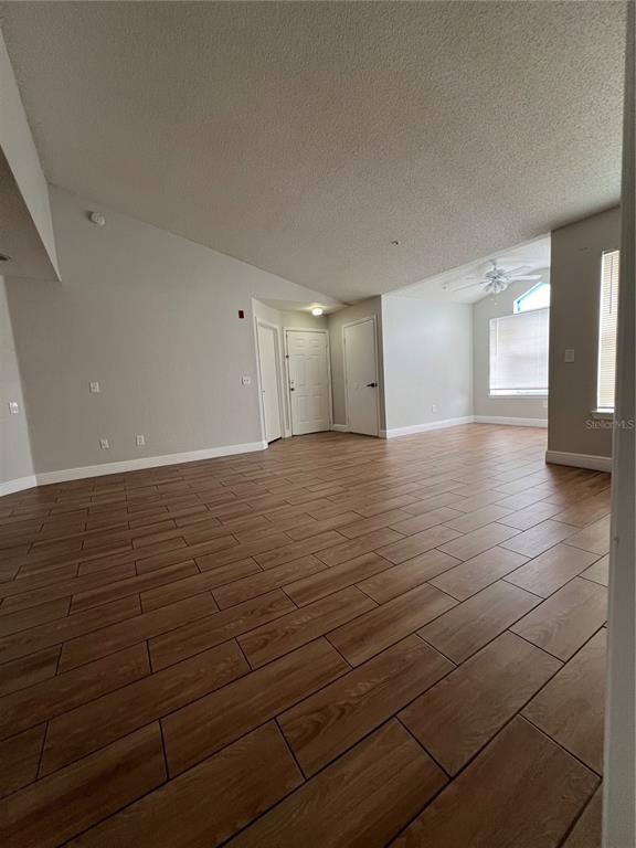 This open-concept living and dining area features light wood-look flooring and neutral-toned furniture — 2216 GRAND CAYMAN COURT UNIT 1435, KISSIMMEE, FL