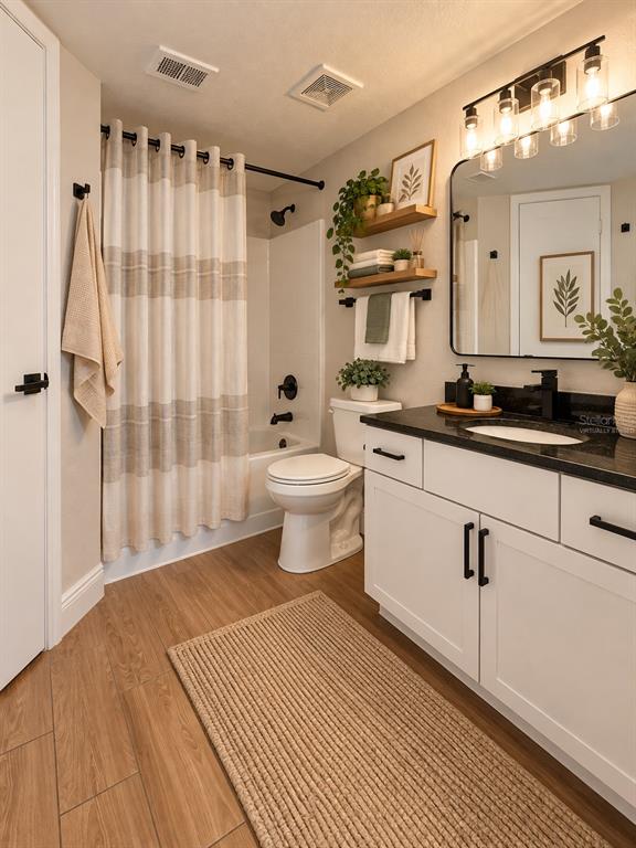 An open-concept living area features wood-look tile flooring and a kitchen with white cabinets — 2216 GRAND CAYMAN COURT UNIT 1435, KISSIMMEE, FL