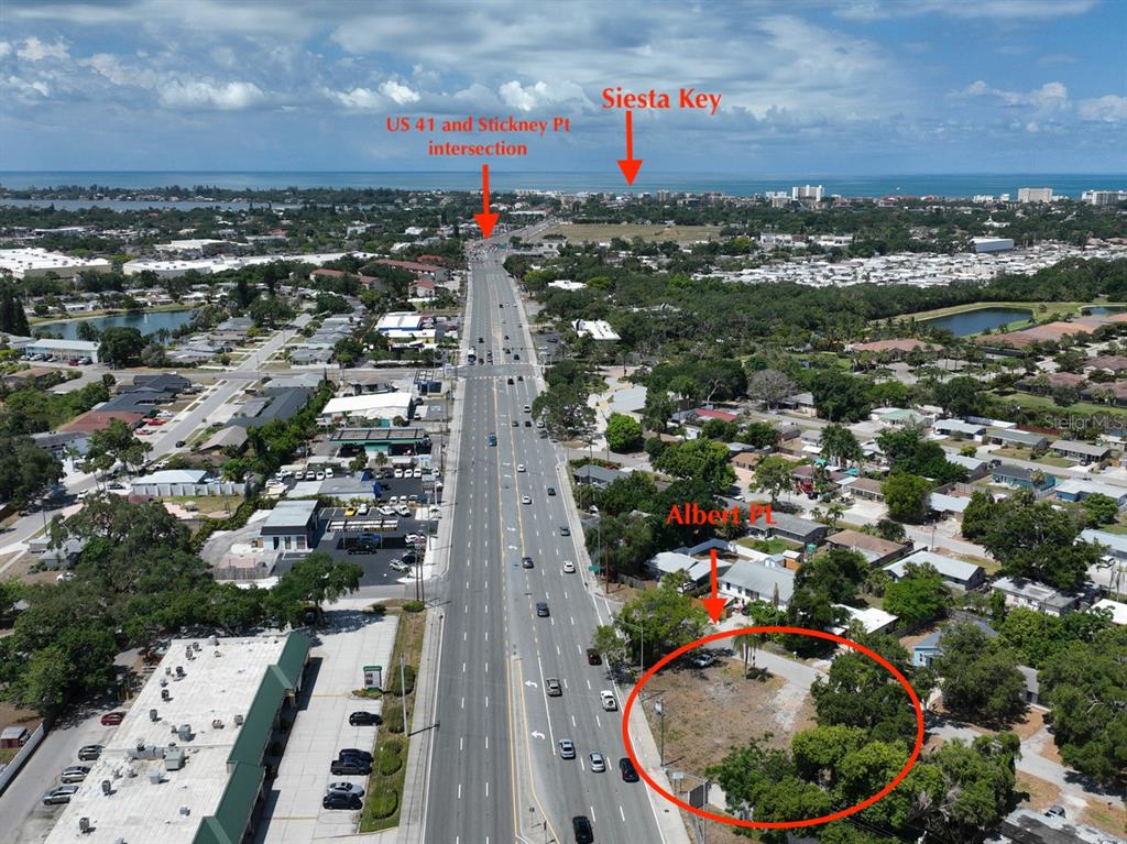An aerial view shows a vacant lot along a multi-lane road near the coast — ALBERT PLACE, SARASOTA, FL