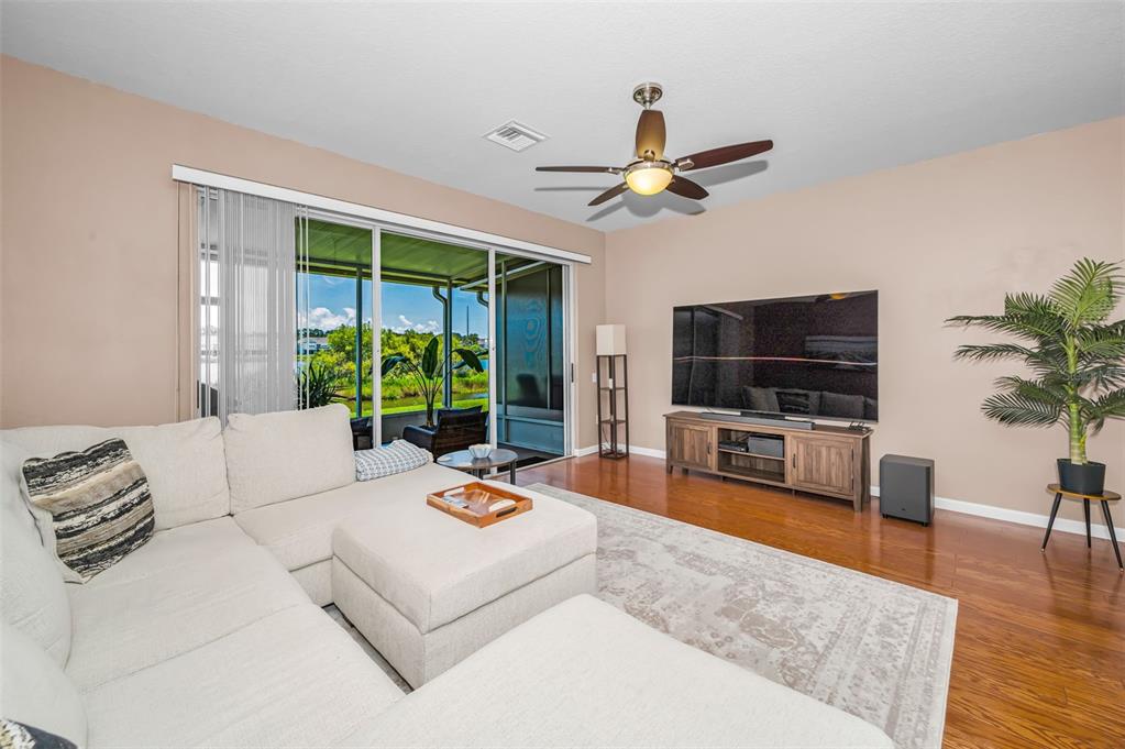 A two-story townhouse with a gray exterior, a single-car garage, and a large magnolia tree — 10155 HAVERHILL RIDGE DRIVE, RIVERVIEW, FL