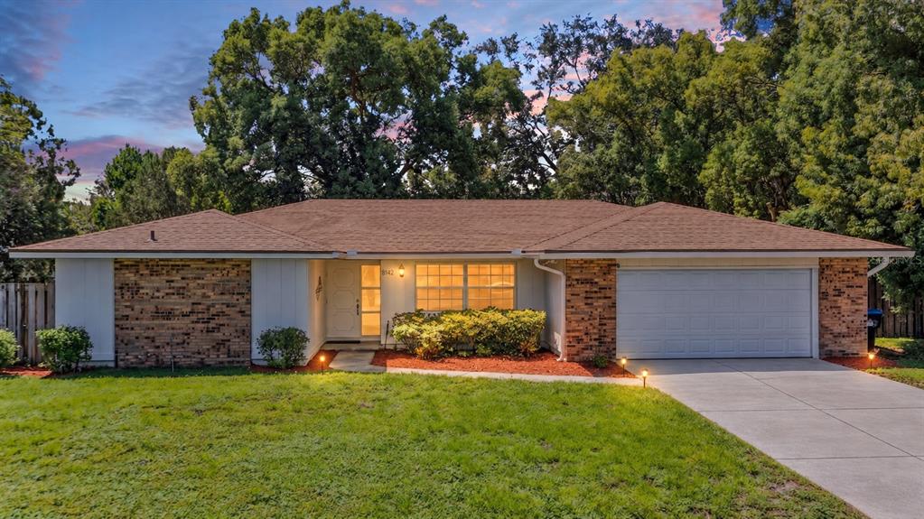 A single-story house with a brick facade, a brown shingled roof, and an attached garage — 8142 GOLDEN SANDS DRIVE, ORLANDO, FL